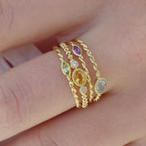 Stapel met Melanie Pigeaud ringen, waaronder de Melanie Pigeaud ring met citrien steen en twee zirkonia's in 9k goud