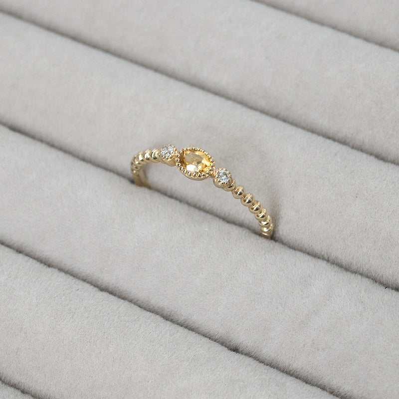 Close up Melanie Pigeaud ring met citrien steen met twee zirkonia's in 9k goud