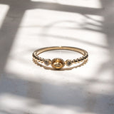 Melanie Pigeaud ring met citrien steen en twee zirkonia's in 9k goud gepresenteerd op marmer